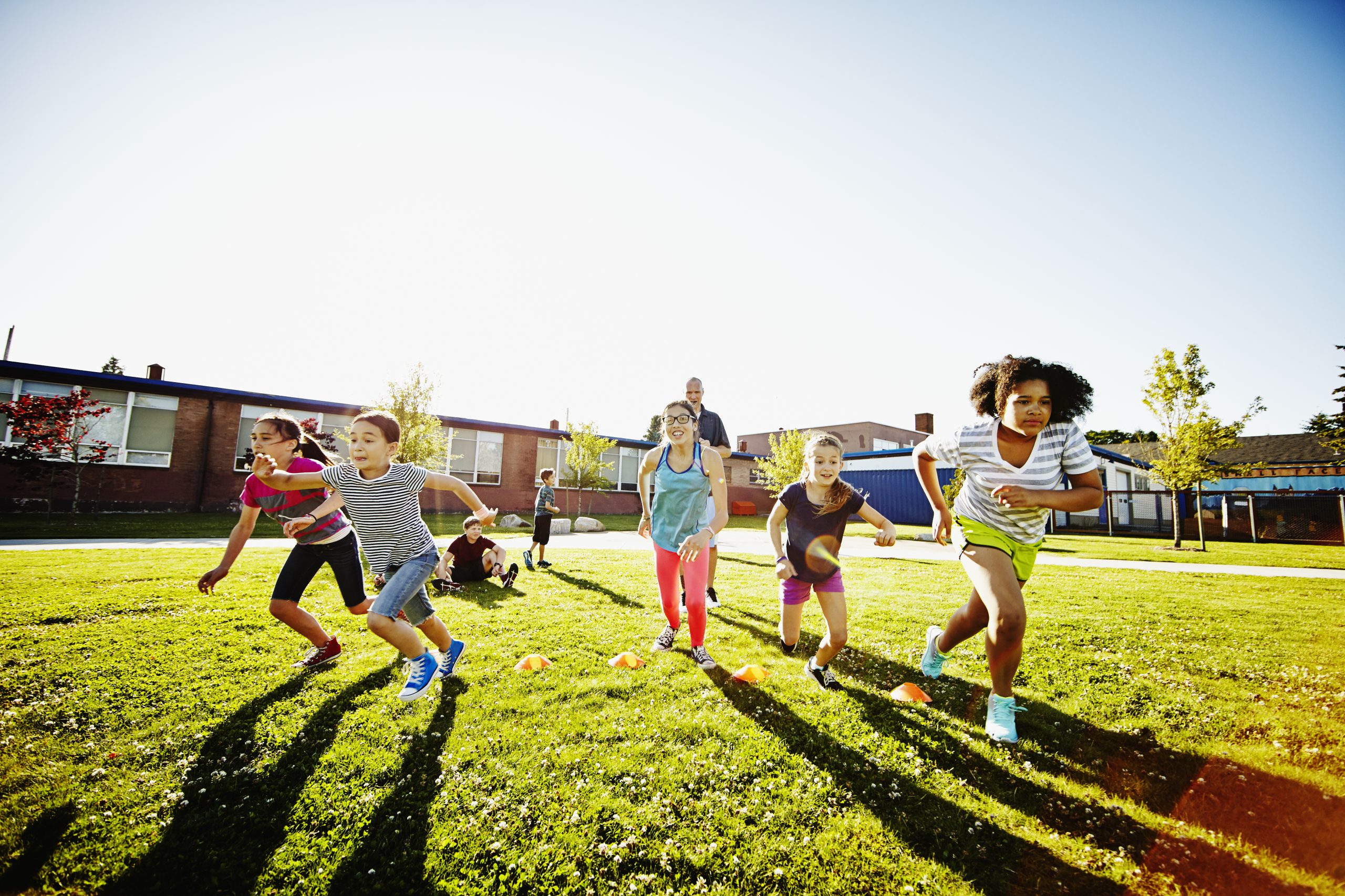 Group of girls running race during athletics class