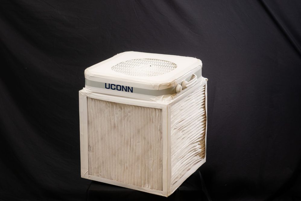 a square white box with four filters on each side and a box fan on top. UConn is written on one side